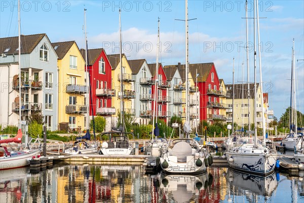 Sailing yachts and colourful houses with holiday flats in the harbour of Greifswald