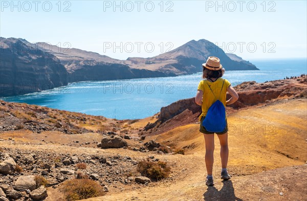 A young woman tourist on the Ponta de Sao Lourenco trail in Baia D'Abra by the beach