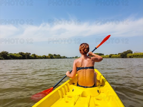 A young woman in the canoe canoeing in a natural park in Catalonia