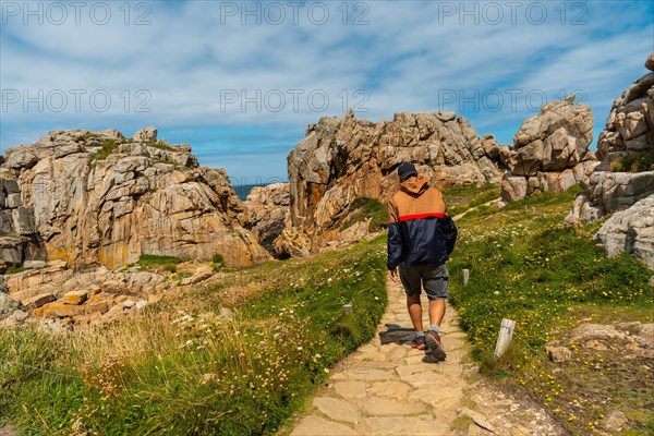 A young tourist walking the trails of Le Gouffre de Plougrescant