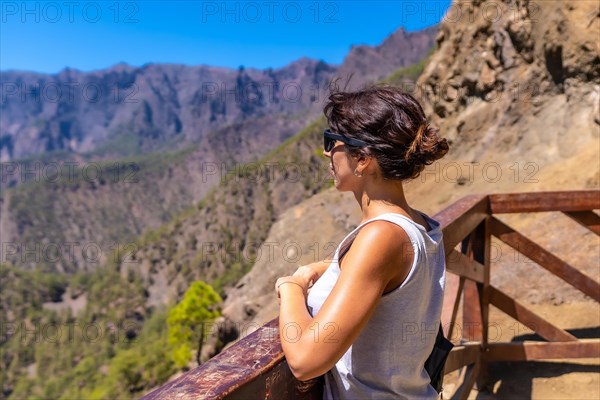 A young tourist looking at the landscape at the Mirador de los Roques on the La Cumbrecita mountain on the island of La Palma next to the Caldera de Taburiente
