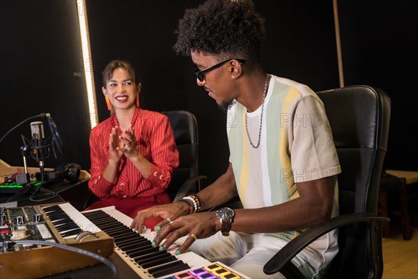 Side view photo of a pianist and singer recording a new album in studio