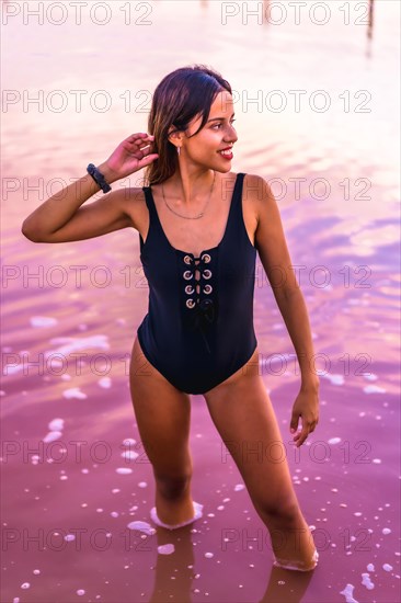 Posing of a young brunette Caucasian on summer vacation in the pink lagoon of Torrevieja