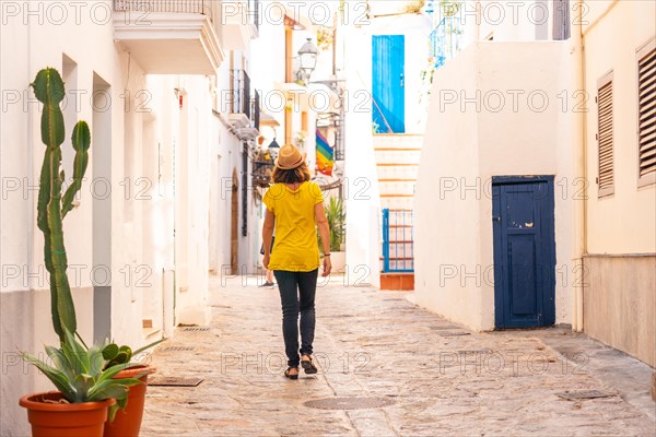 A young woman with a hat visiting the old town of Ibiza