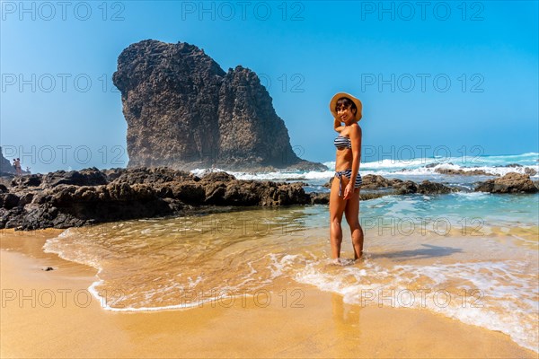 A young tourist smiling in the Roque del Moro of the Cofete beach of the natural park of Jandia