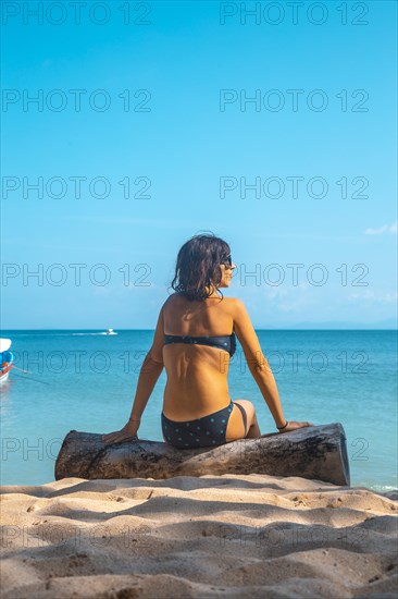 A young girl sitting on the beach in Punta de Sal