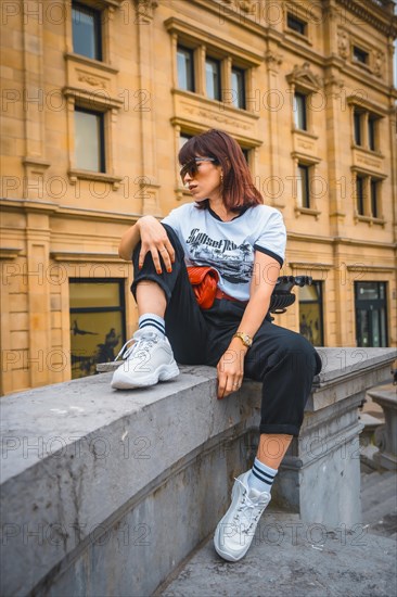 Lifestyle in the city. A young brunette in sunglasses