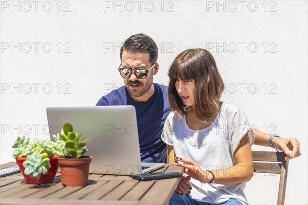 A couple confined at home making a video call with some friends with the computer