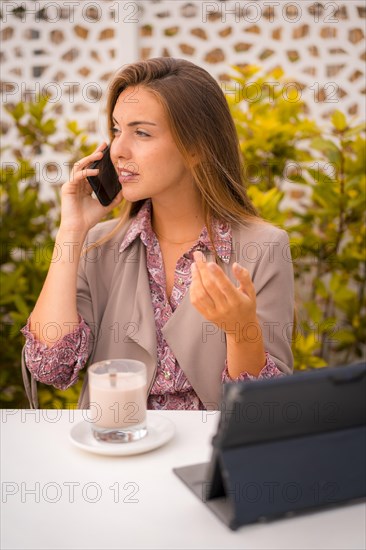 Female executive and businesswoman having breakfast in a cafe decaf and looking at email