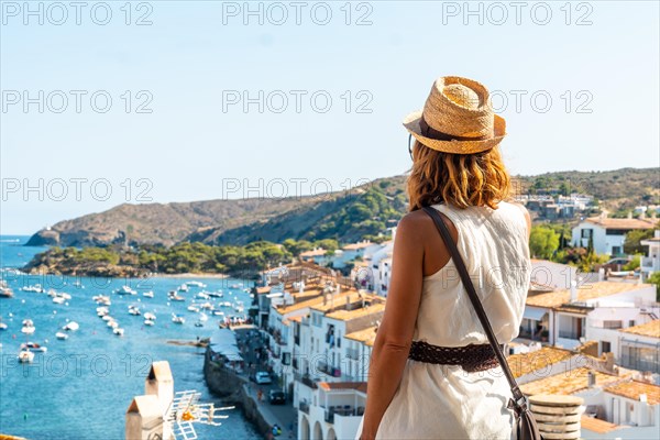 A young woman on vacation looking at the city of Cadaques from a viewpoint