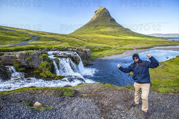 A boy in the famous Icelandic mountain Kirkjufell and the small waterfalls