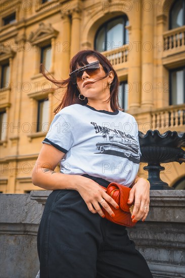 Lifestyle in the city. A young brunette in sunglasses