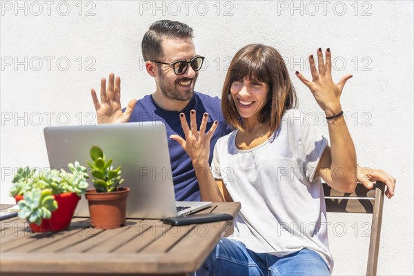 A couple confined at home making a video call with some friends with the computer