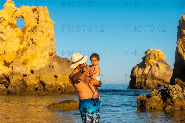 A father with his baby in the water at Praia dos Arrifes