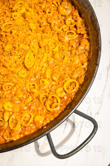 Details of the Valencian paella made on wood and vegetable embers. Traditional Spanish Mediterranean food of fish and seafood