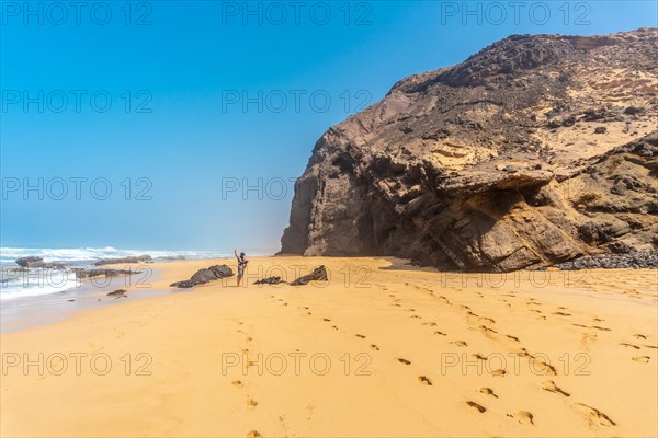 A young father in the Roque del Moro of the Cofete beach of the natural park of Jandia