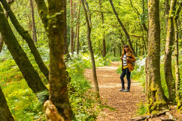 A young woman trekking on Lake Paimpont in the Broceliande forest