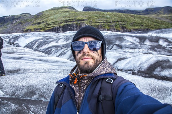 A young man with booties and hammer on the trekking of the Svinafellsjokull glacier. Iceland