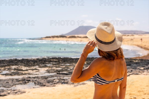 A young tourist with a hat on the beaches of the Corralejo Natural Park