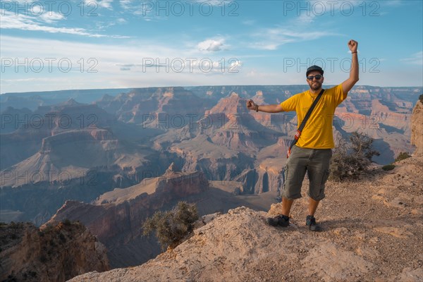 A man in a yellow shirt enjoying the sunset views at Mojave Point in Grand Canyon. Arizona