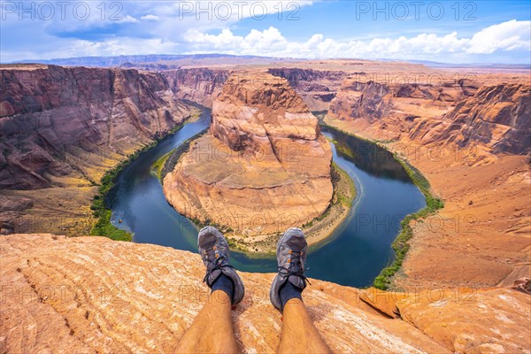 Crossed feet resting watching Horseshoe Bend and the Colorado River in the background