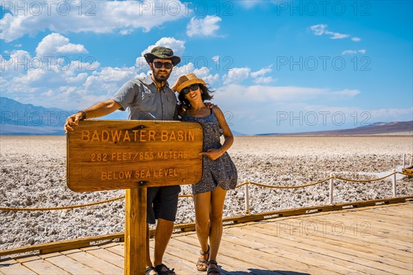 A couple tourists walking white salt of Badwater Basin