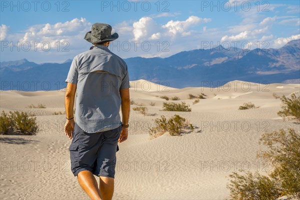 A young man with a blue shirt in the desert of Death Valley