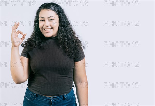 Smiling young woman gesturing ok isolated. Happy girl with thumbs up isolated. Smiling people showing ok gesture isolated