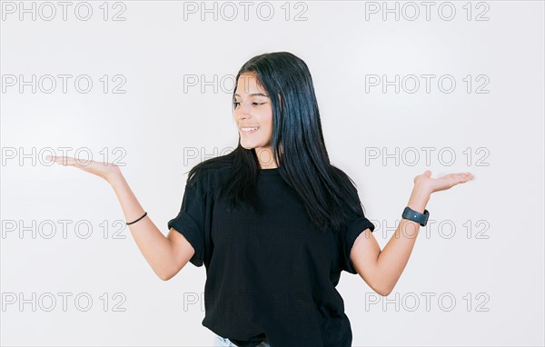 Girl balancing something with palms isolated. Smiling woman comparing with palms with hands isolated