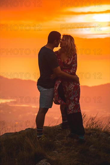 Parents with their son on top of a mountain at sunset