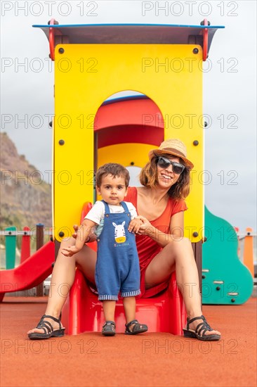 Baby playing in a playground having fun in summer