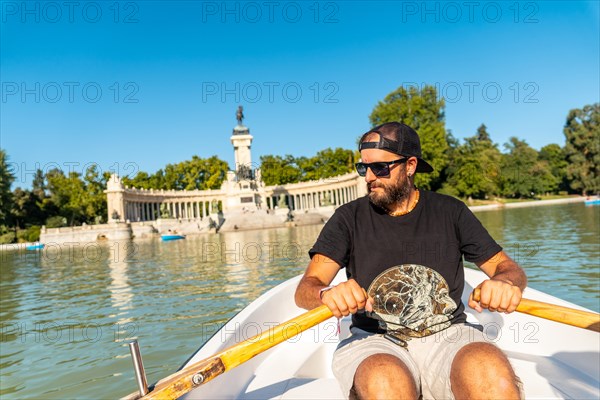 A tourist rowing the boat in the Estanque Grande de El Retiro in the city of Madrid. Spain