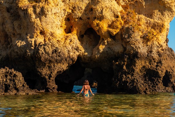 A woman in the water on a bow at Praia dos Arrifes