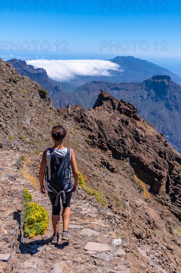 A young woman walking along the path of the Roque de los Muchachos at the top of the Caldera de Taburiente