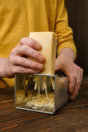 Close up view of grating cheese using hand grater