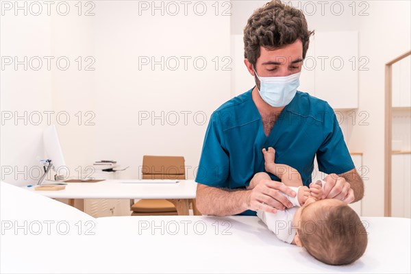 Photo with copy space of a doctor examining a newborn baby lying on a stretcher in a clinic