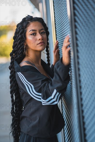 Urban session. Young woman of black ethnicity with long braids and with tattoos