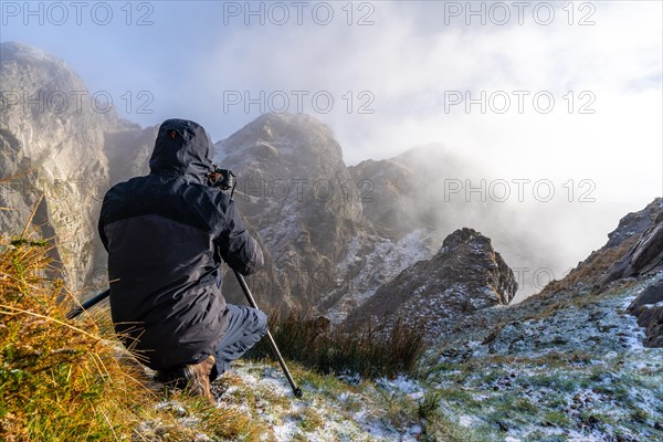 A photographer taking a photo with the tripod in the snowy winter sunset