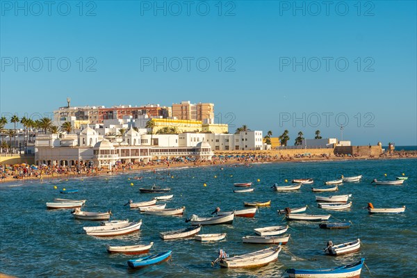 La Caleta beach full of tourism in the summer sunset of the city of Cadiz. Andalusia