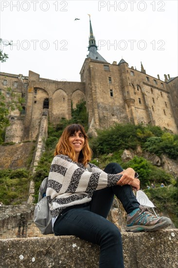 A young tourist visiting the famous Mont Saint-Michel Abbey in the Manche department