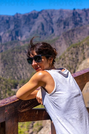 A young tourist looking at the landscape at the Mirador de los Roques on the La Cumbrecita mountain on the island of La Palma next to the Caldera de Taburiente