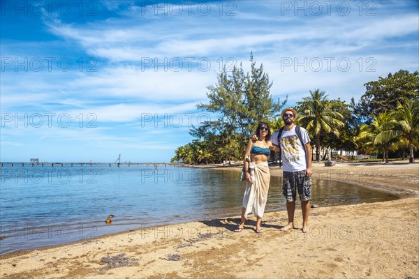 Two young men on the beach of Sandy Bay on Roatan Island. Honduras