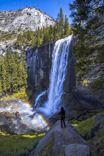 A woman in Long Vernal Falls waterfall in Yosemite National Park. California