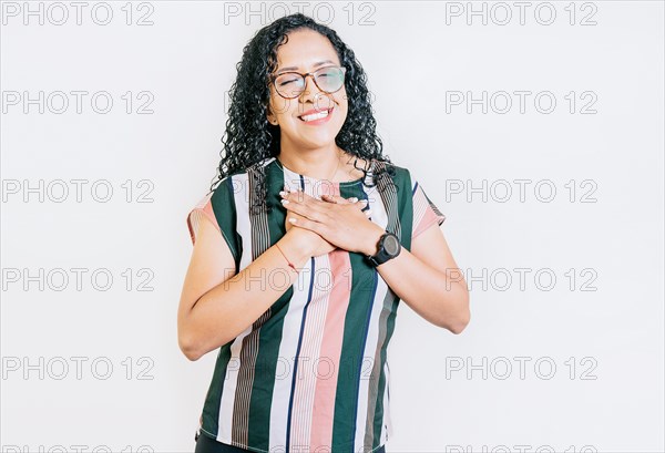 Positive smiling girl with hands on chest. Grateful people with hands on chest. Grateful young woman smiling with hands on chest isolated