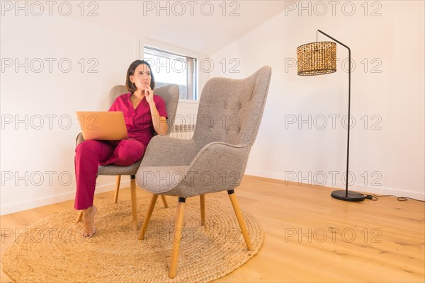 Nutritionist working from home sitting on a couch in a minimalist room