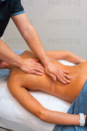 Physiotherapeutic massage to an unrecognizable woman lying on a stretcher on her back