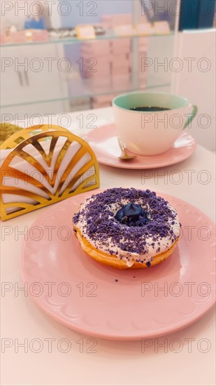 Ube or purple yam flavored donut in a cute pink pastel color themed cafe