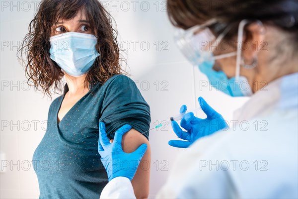 Coronavirus vaccine applied to a young woman by a doctor. Antibodies