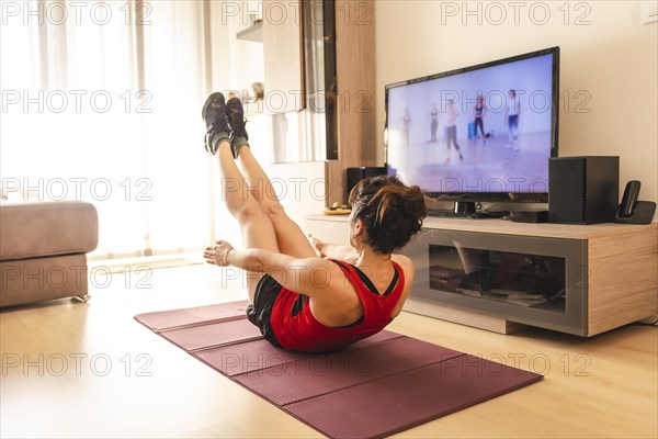 A young woman doing sports in her living room. Sport in the quarantine at home