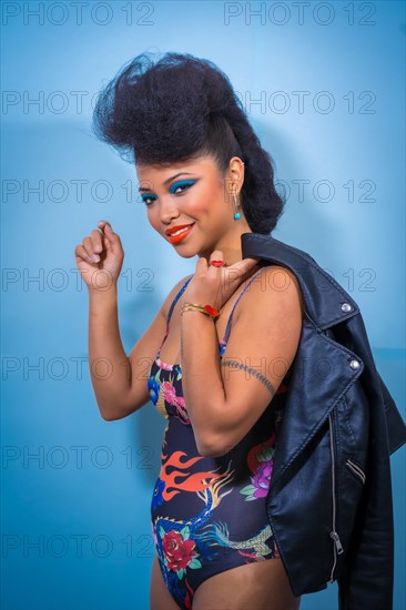 A closeup portrait of a fashion attractive rocker style woman with bright makeup wearing a leather jacket